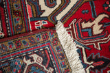 Intact side cord selvage and hand-knotted weave on a vintage Persian Mehrivan carpet corner.
