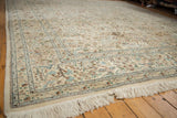 Angled view displaying the full, plush pile and intact ivory fringe of a vintage Tabriz rug.