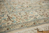 Ornate corner and border detail of a vintage Tabriz rug, showing the plush ivory wool pile and fringe.