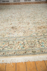 Angled view of a vintage Tabriz carpet's full pile, ornate pictorial border, and clean fringe.