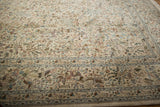 Angled view of the vintage Tabriz rug's intricate pictorial border featuring pheasants and trees.