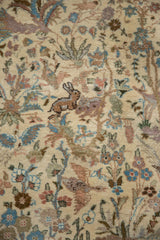 A hand-knotted rabbit motif among dusty blush and powder blue florals on a vintage Tabriz carpet.