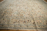 Angled view across the dense, pictorial forest scene of a vintage Persian Tabriz square carpet.