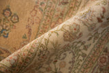 The soft, full pile and even texture of a vintage Tabriz carpet with muted floral details.