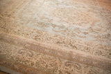 A vintage Tabriz carpet's intricate floral designs on its ivory border and powder blue field.