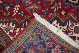 Corner of a vintage Mehrivan carpet folded to show the plush pile, turtle design border, and clean ivory fringe.