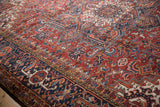 Vintage Heriz carpet with brick red field, geometric patterns, and stylized blossoms.