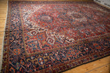 Vintage Heriz hand-knotted rug section with brick red field, navy border, and colorful geometric florals.