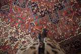 Close-up of the full pile and geometric serrated leaf motifs on a vintage Heriz carpet.
