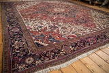 Plush wool pile on a vintage Heriz carpet, focusing on the navy geometric border and ivory fringe.
