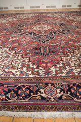 Floor-level view of a vintage Heriz carpet emphasizing the plush, full pile and intricate geometric border.