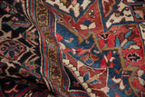Detailed view of the plush wool pile on a vintage Heriz carpet, showing geometric motifs in navy blue and brick red.