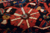 Hand-knotted dark brick red blossom, ivory, and sapphire blue on vintage Heriz rug.
