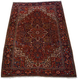 Upper corner of Vintage Heriz carpet, showcasing geometric vinery, tendrils in brick red, navy, ivory.