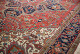 Saturated rust red and navy blue geometric floral motifs on a vintage hand-knotted Mehrivan carpet.
