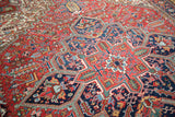 Angled view showing the intricate geometric patterns and rich colors of a vintage Mehrivan carpet.