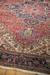 Corner view of a vintage Mehrivan carpet showing the geometric navy border and secured white fringe.