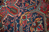Intricate geometric floral details in saturated navy blue, rust red, and saffron on a full pile vintage rug.
