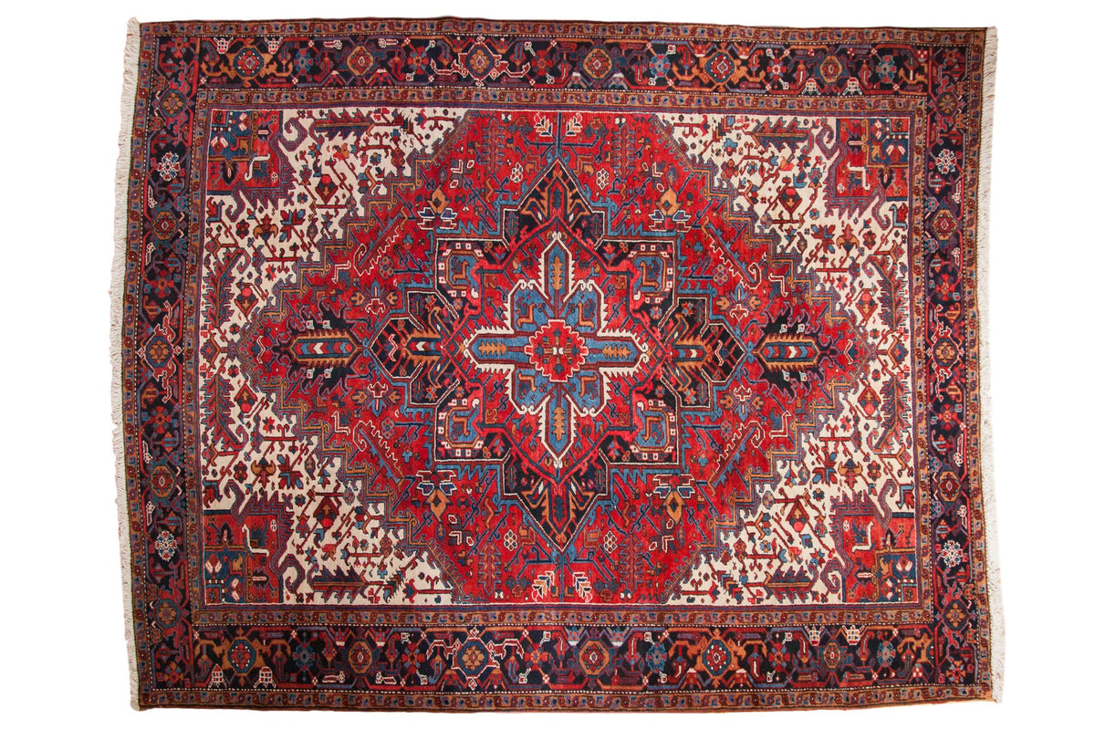 Vintage Persian Heriz carpet with a classic concentric medallion in cherry red, dark navy, and sky blue.