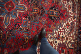 Full, plush pile of a vintage Heriz carpet with bold geometric patterns in red, navy, and sky blue.