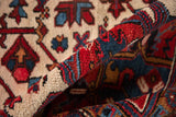 Vibrant cherry red and navy blue patterns on the full, plush pile of a vintage Heriz carpet.