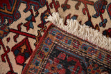 The hand-knotted foundation, intact red side cord, and ivory fringe of a vintage Heriz carpet.