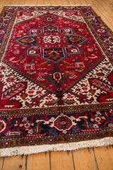 Low angle view of a vintage Mehrivan carpet's full pile, geometric design, and ivory fringe.
