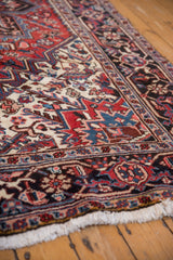 Fringed corner of Vintage Mehrivan carpet with full pile, traditional brick red and navy patterns.