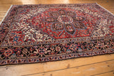 Vintage Mehrivan rug's dark navy border, geometric floral motifs, and brick red field.