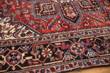 Traditional curvilinear patterns in red, navy, and ivory on a Mehrivan rug border.