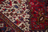 Plush, hand-knotted wool pile revealing crisp geometric vinery in red, blue, and gold.