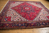 Vintage Mehrivan Persian carpet from an angle, highlighting its bold red starburst medallion.