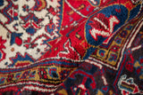 The thick, even pile of a hand-knotted Mehrivan rug in cherry red, navy, and ivory tones.