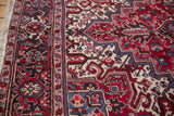 Close-up of the Persian Mehrivan's turtle design border and even pile in red, navy, and ivory.