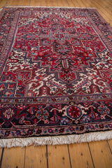 Angled view of the Mehrivan carpet's corner showing the geometric turtle border and ivory fringe.