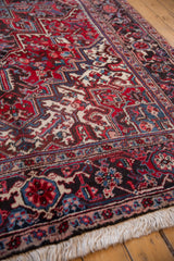 Angled view of the vintage Mehrivan carpet's turtle border, wool pile, and clean ivory fringe.