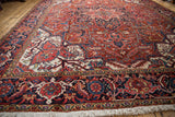 Corner of a vintage Heriz carpet with its Samovar Turtle border, plush pile, and fringe.
