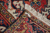 The hand-knotted back and original ivory fringe of a vintage Persian Heriz carpet corner.