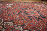 Low-angle view of the vintage Heriz carpet's full pile showing its scrolling vinery and serrated leaves.