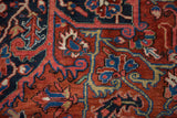 Detail of serrated leaves and scrolling vinery in the dense, hand-knotted pile of a vintage Heriz carpet.
