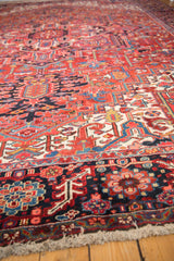 Low angle view across the dense wool pile of a vintage Heriz carpet, showing detailed geometric motifs.