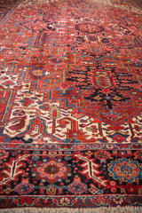 Richly colored geometric motifs and the dense pile of a vintage Persian Heriz carpet.