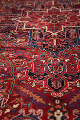 Close view of a vintage Heriz carpet's full pile and sharp contours in red and navy.