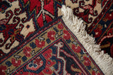 Original navy blue side cord and clean ivory fringe on the corner of a full pile vintage Heriz rug.