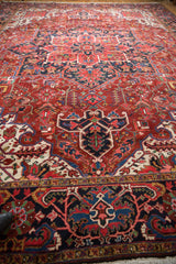 Low angle perspective of a vintage Ahar carpet's full pile and intricate Heriz-style design.