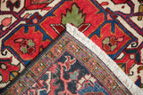 Folded corner of a vintage Ahar carpet revealing the full pile and the intricate hand-knotted back weave.
