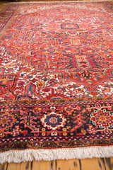 Corner detail of a vintage Heriz carpet's plush pile, with a navy floral border and full ivory fringe.