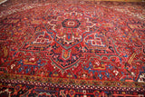 Close perspective on the lush, full pile and geometric palmettes of a vintage Heriz carpet.