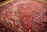 An angled view showcasing the rich texture and complex geometric design of a vintage Heriz carpet.