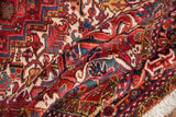 The full, plush pile of a vintage Heriz carpet showing the meandering floral border and ivory fringe.